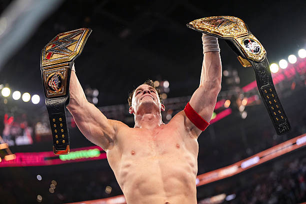 John Cena celebrates with the Undisputed WWE Championship and the World Heavyweight Championship during Saturday Night's Main Event 